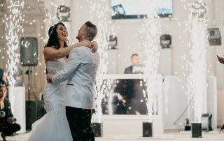 A man and woman dancing in a room with water spouting.